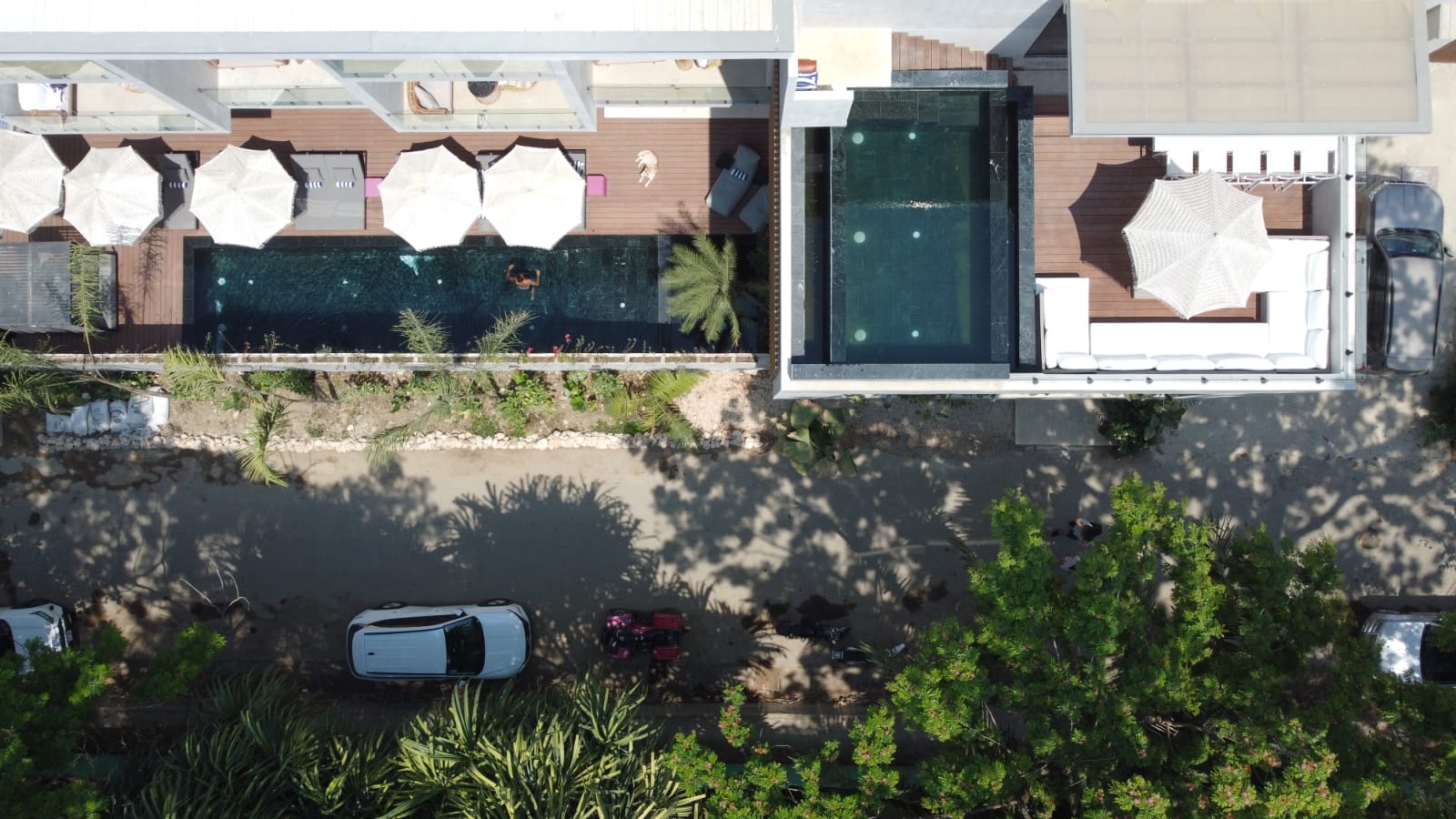 Top-down drone view of pools and parking