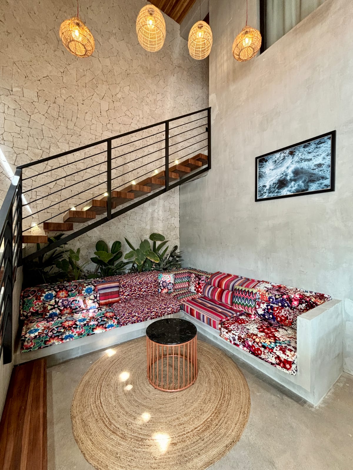 Communal lounge with patterned cushions under stairs